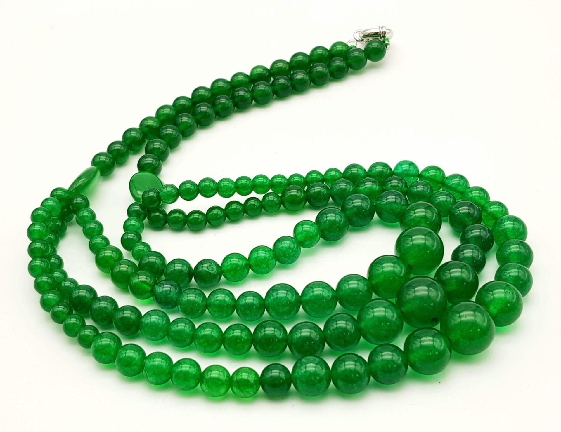 A Chinese Expansive Three Row Green Jade Necklace. A green jade bead necklace gives way to a three - Image 4 of 7