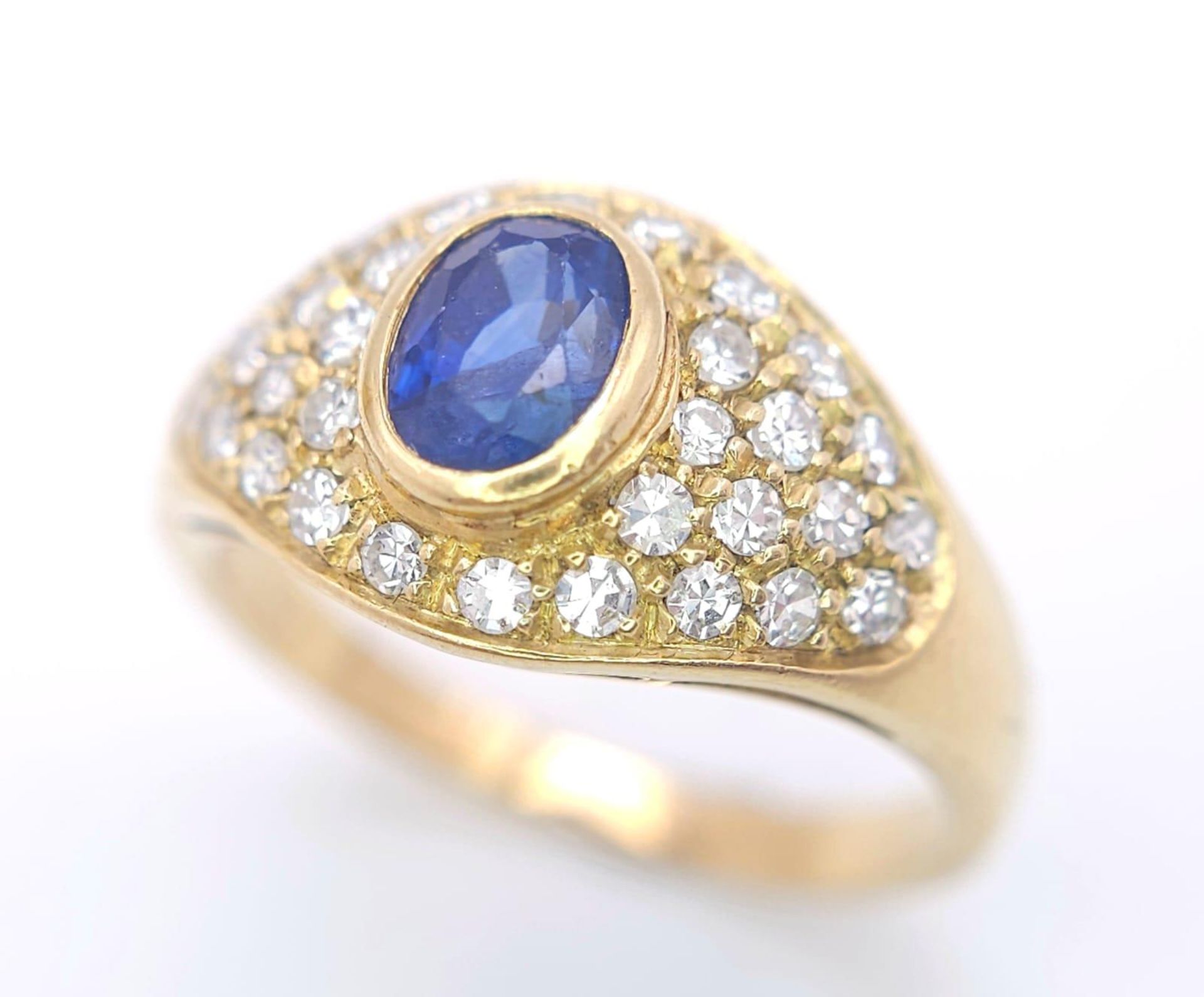 AN 18K YELLOW GOLD FANCY DIAMOND & SAPPHIRE RING. 0.75CTW OF 8 CUT DIAMONDS AND A 0.75CT OVAL