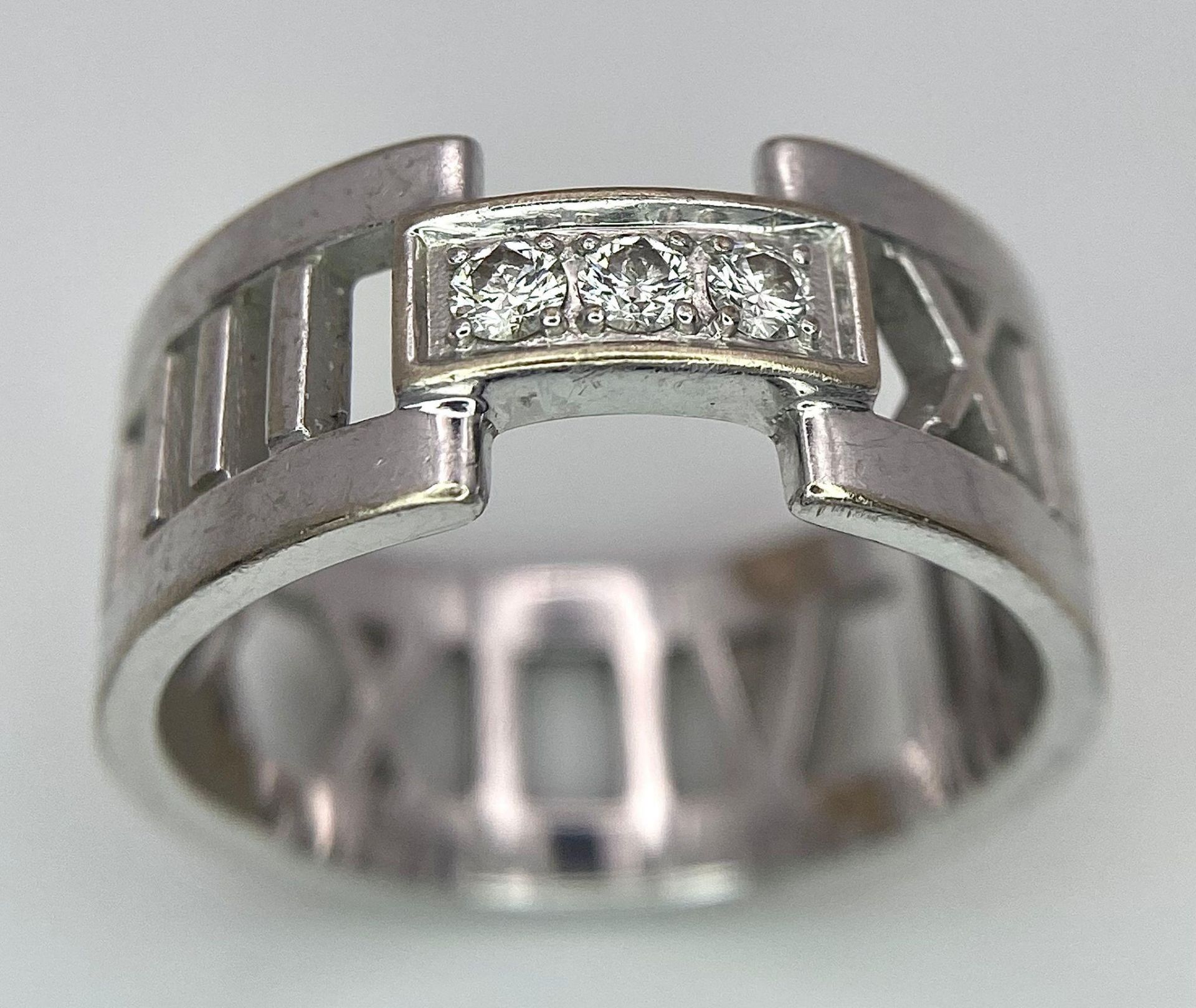 An 18K White Gold Tiffany Atlas Diamond Ring. Pierced Roman numeral decoration. Tiffany mark. Size - Image 2 of 9