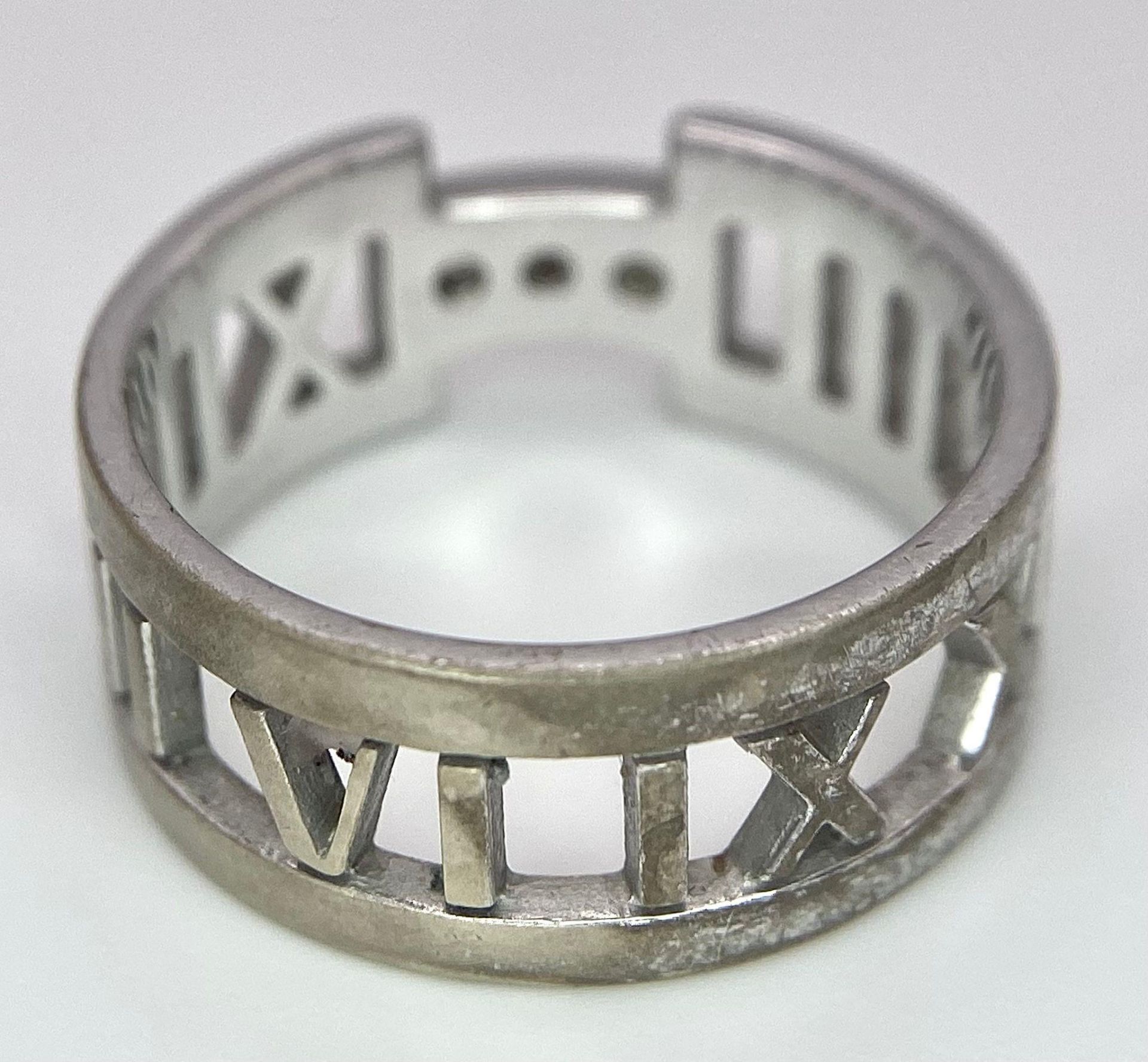 An 18K White Gold Tiffany Atlas Diamond Ring. Pierced Roman numeral decoration. Tiffany mark. Size - Image 8 of 9