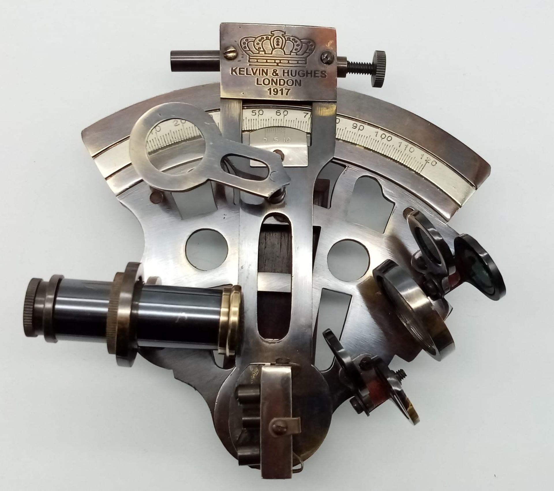 A very ornamental, brass sextant, with many moving parts and an inscription KELVIN & HUGHES LONDON