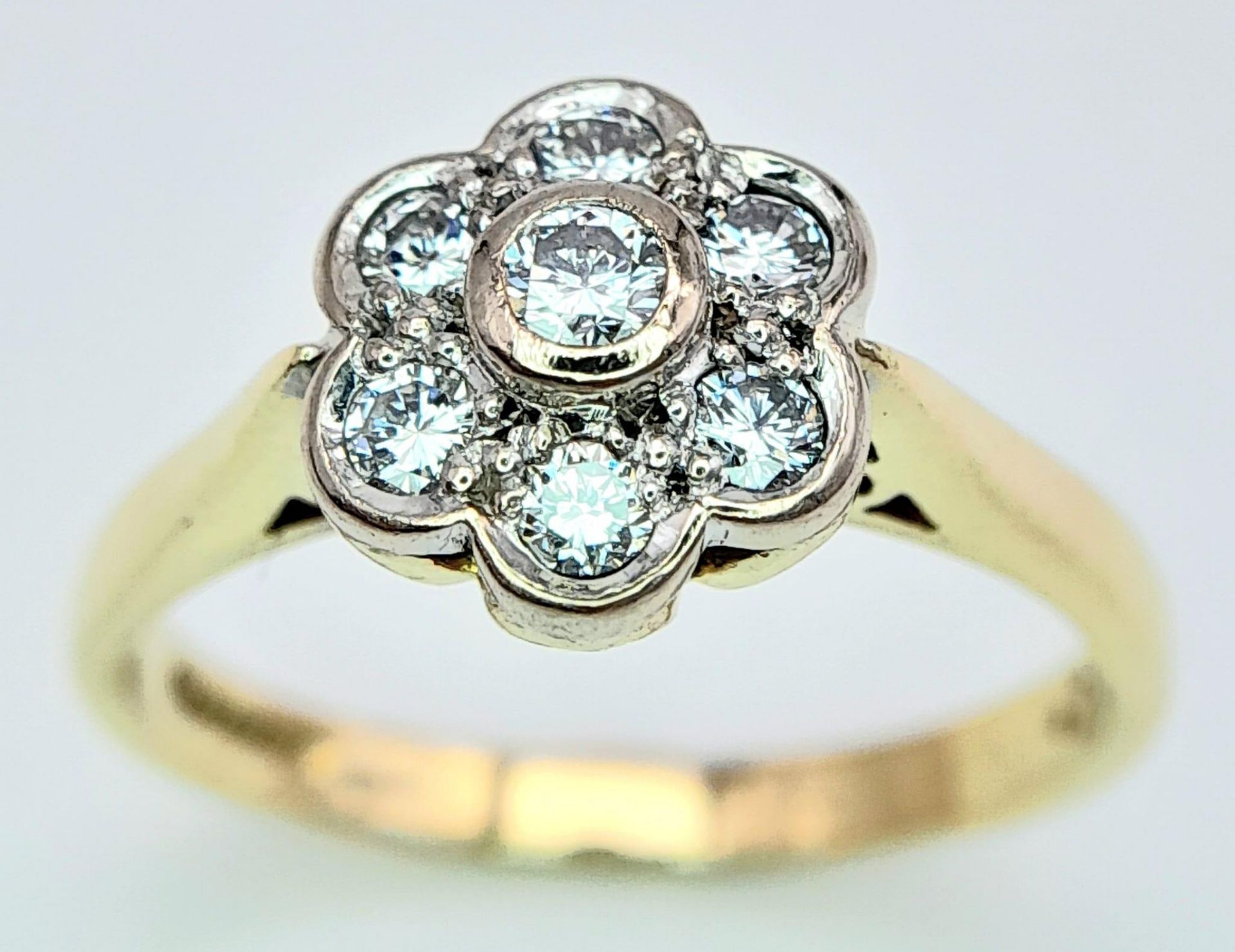 AN 18K YELLOW GOLD DIAMOND FLOWER CLUSTER RING. 0.25CTW. 3.8G. SIZE M.