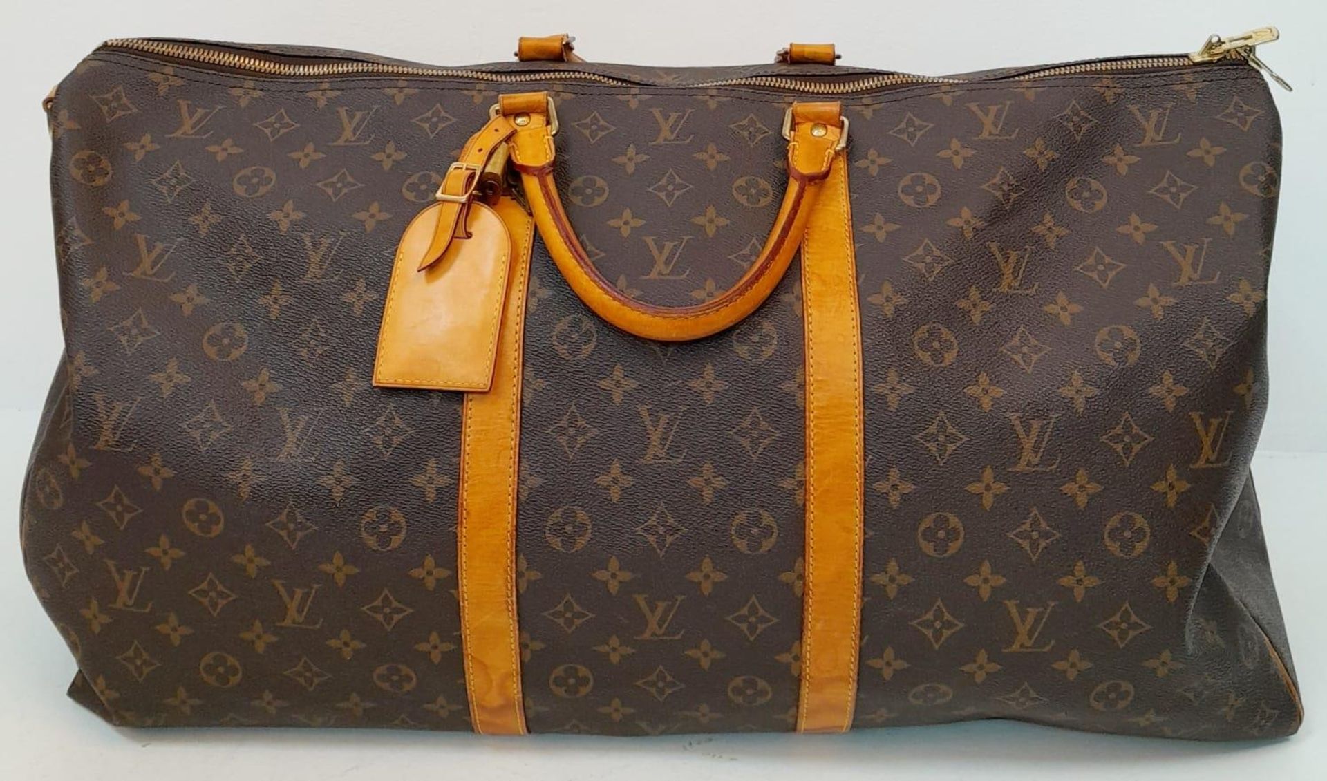 A Large Louis Vuitton Keepall Travel Bag. Monogram LV canvas exterior with cowhide leather handles