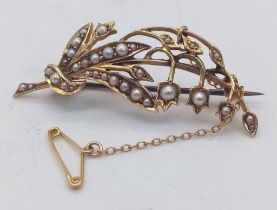 An antique 15 K yellow gold floral brooch with natural seed pearls and security chain, dimensions: