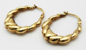 A 9 K yellow gold pair of hoop earrings with a twisted design, length: 25 mm, weight: 1.7 g.
