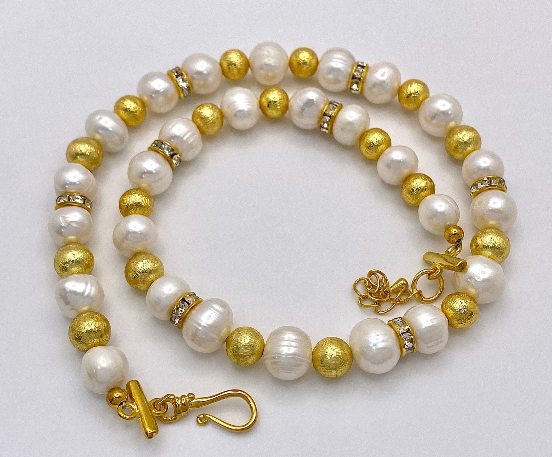 A classy, fresh water cultured white pearl necklace and earrings set, with gold plated parts and - Image 2 of 3