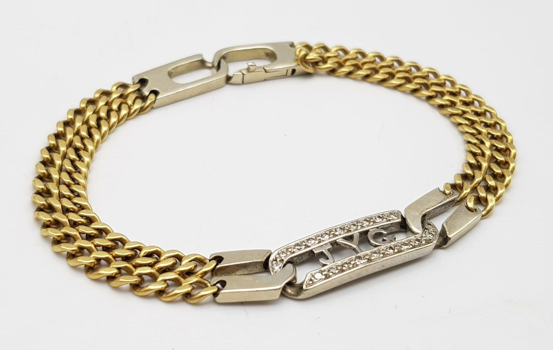 An 18K Yellow and White gold Diamond Bracelet. A double row of flat yellow gold curb links connect