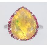 An 18 K white gold ring with a large, pear cut, fire opal exhibiting orange and green hues,