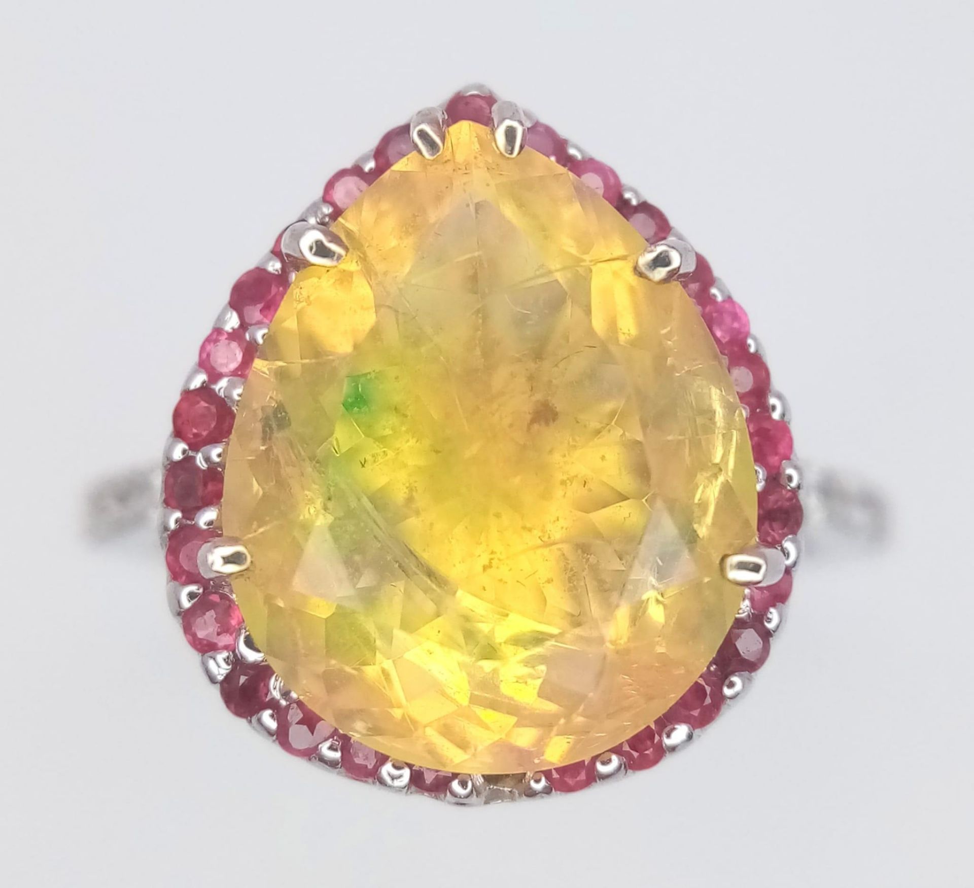 An 18 K white gold ring with a large, pear cut, fire opal exhibiting orange and green hues,