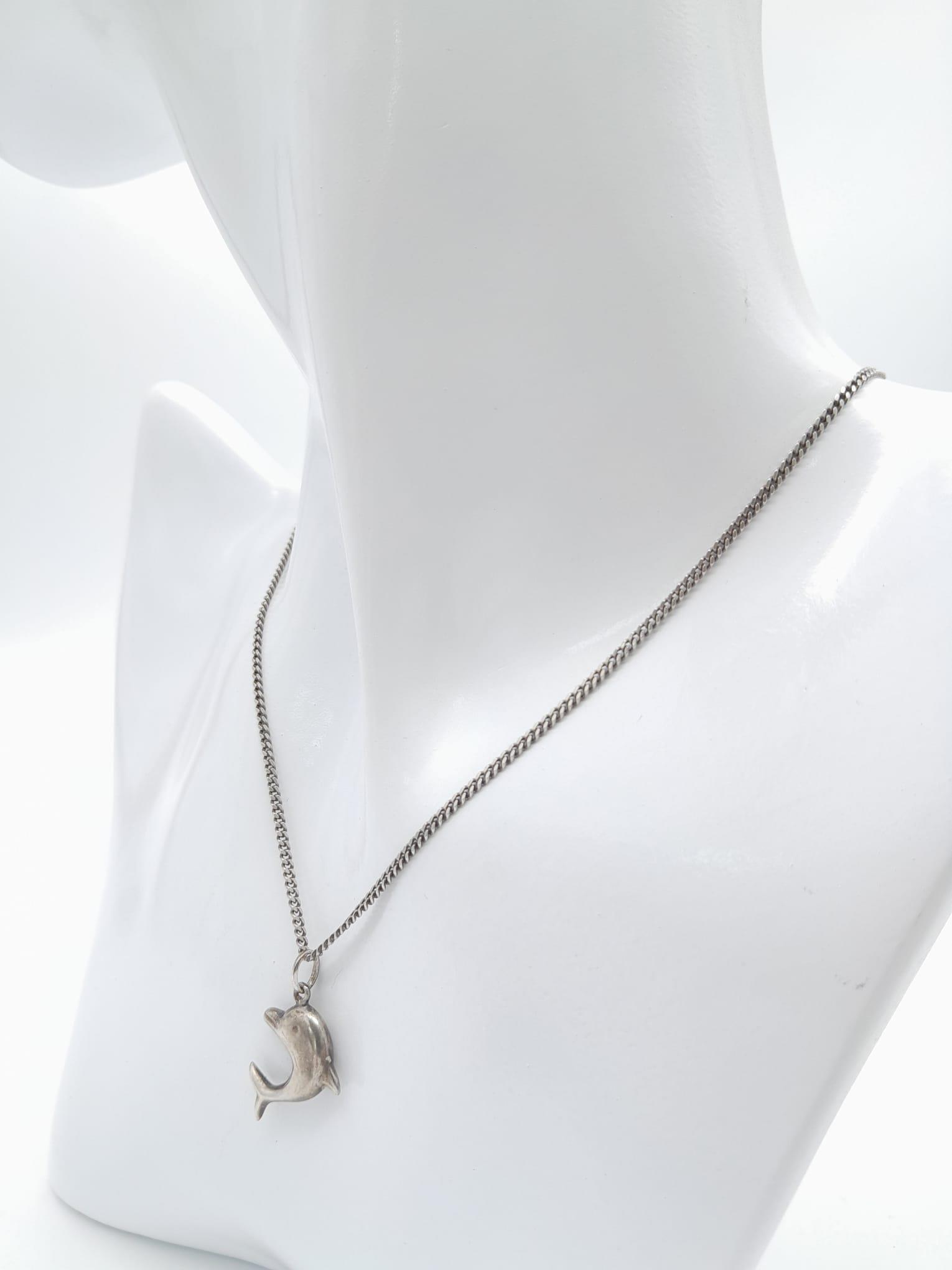 A vintage sterling silver dolphin pendant on silver curb chain. Total weight 4.2G. Total length - Image 4 of 6