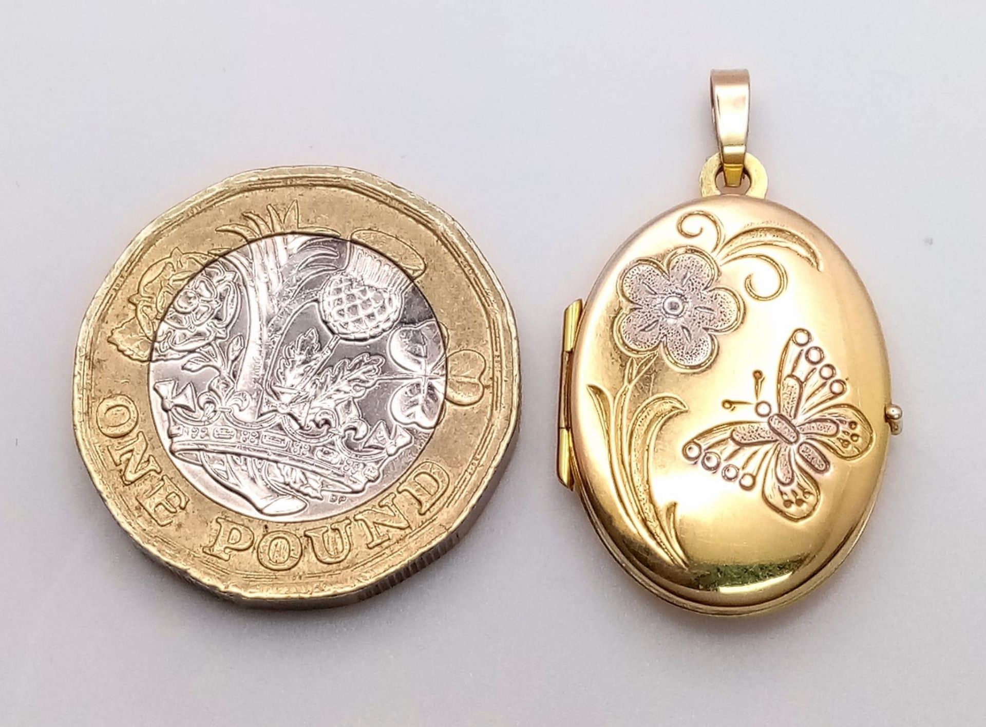 A 9K Yellow Gold Oval Locket Pendant. Decorative white gold floral scene. 3cm. 2.2g weight. - Image 5 of 5