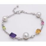 An 18 K white gold chain bracelet with a variety of gemstones (peridot, amethyst, citrine, etc)