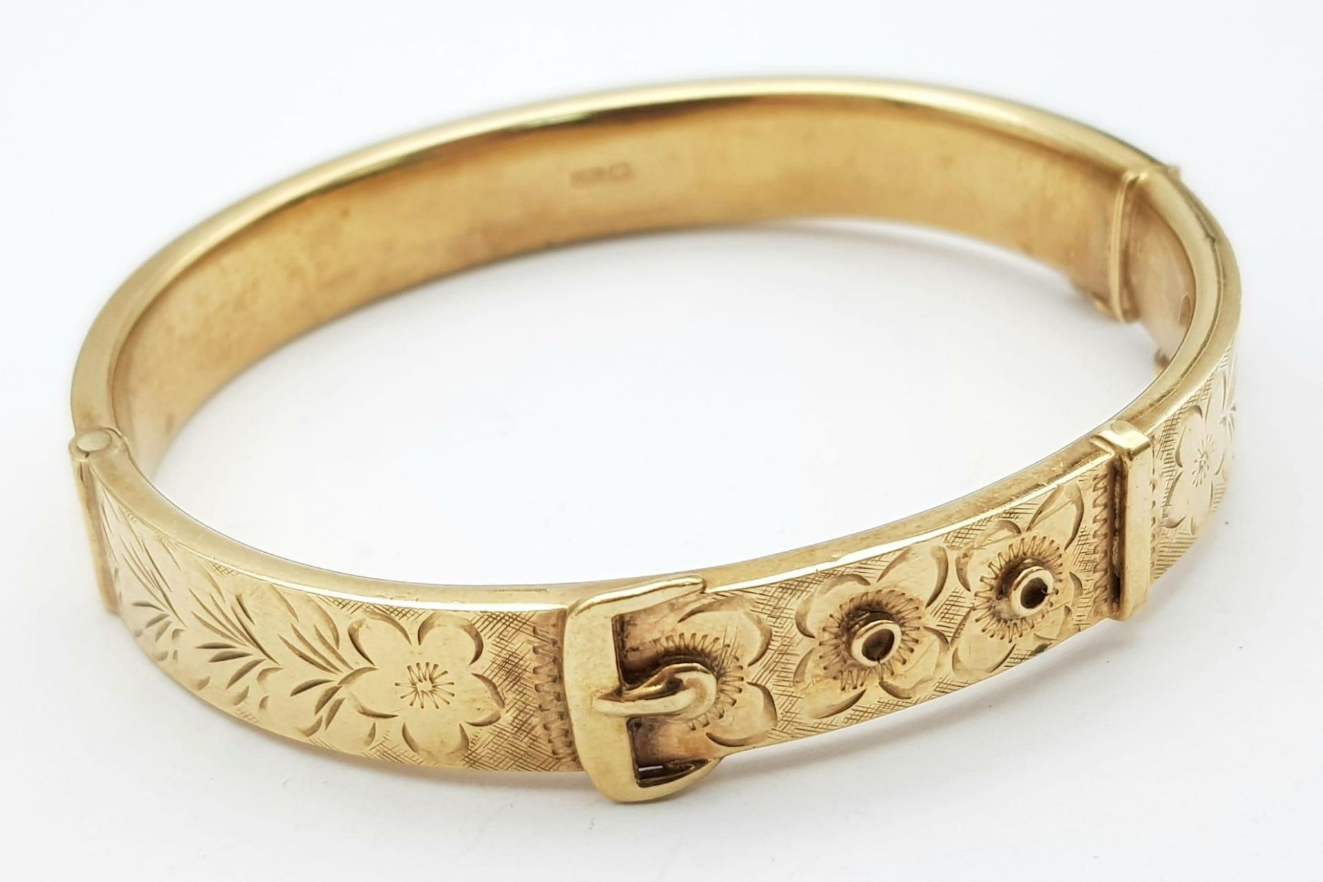 A Vintage 9K Yellow Gold Bangle. Belt buckle design. Clip open function. 6cm inner diameter. 15.7g