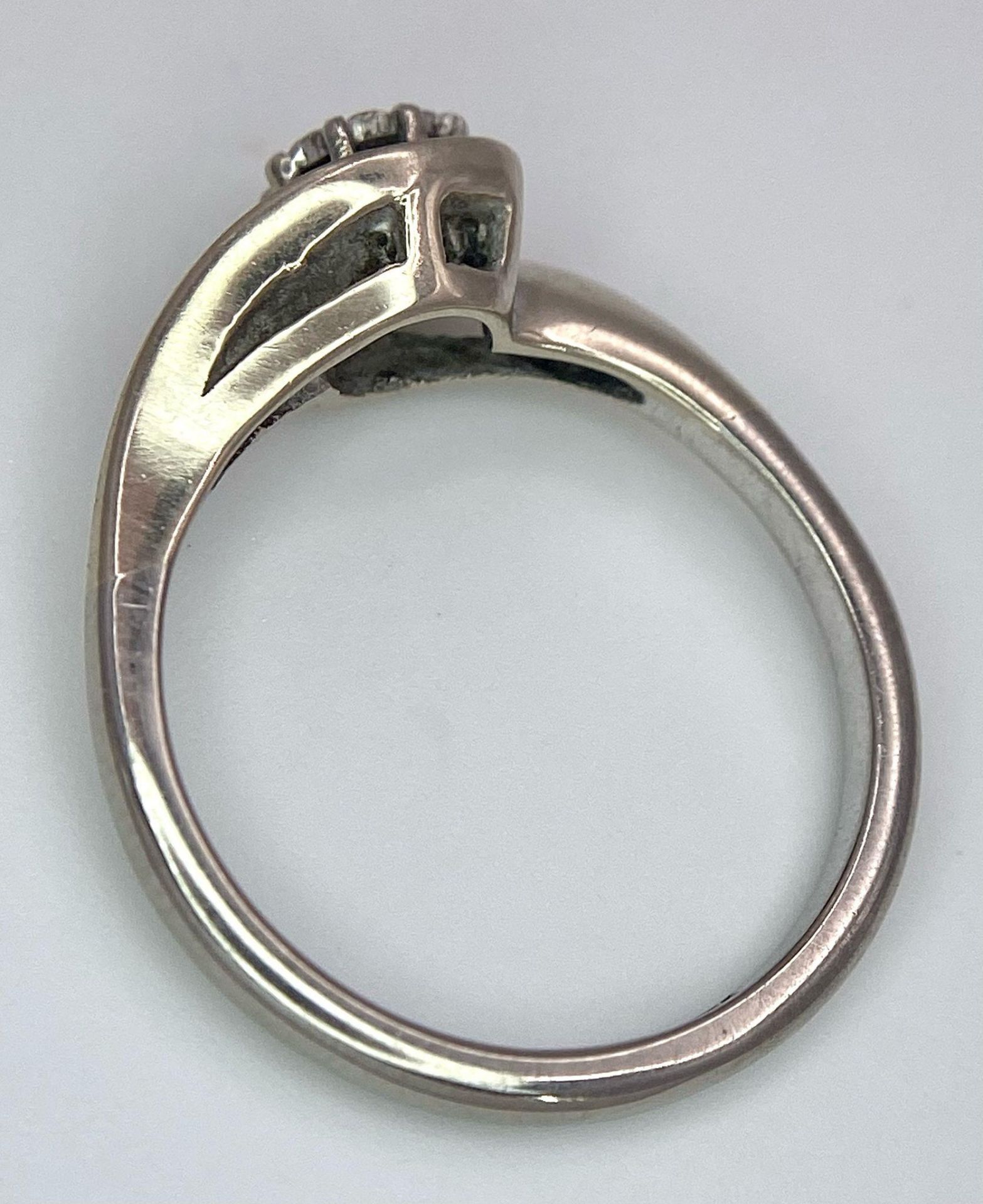 An 18K White Gold Diamond Crossover Ring. 0.10ct brilliant round cut diamond. Size N. 4g total - Image 5 of 6