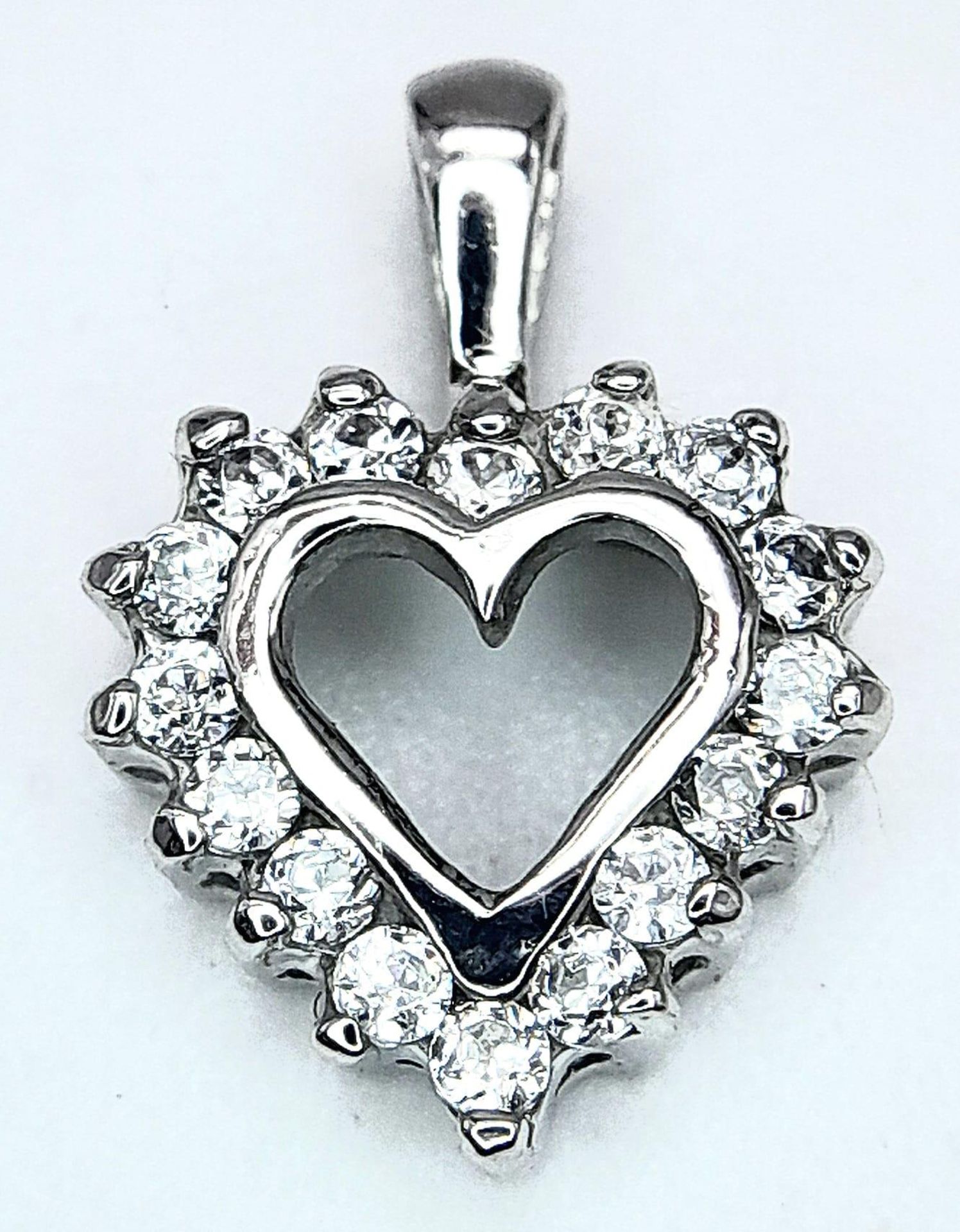 A 9K WHITE GOLD DIAMOND SET HEART PENDANT. 0.20CT. 0.8G.