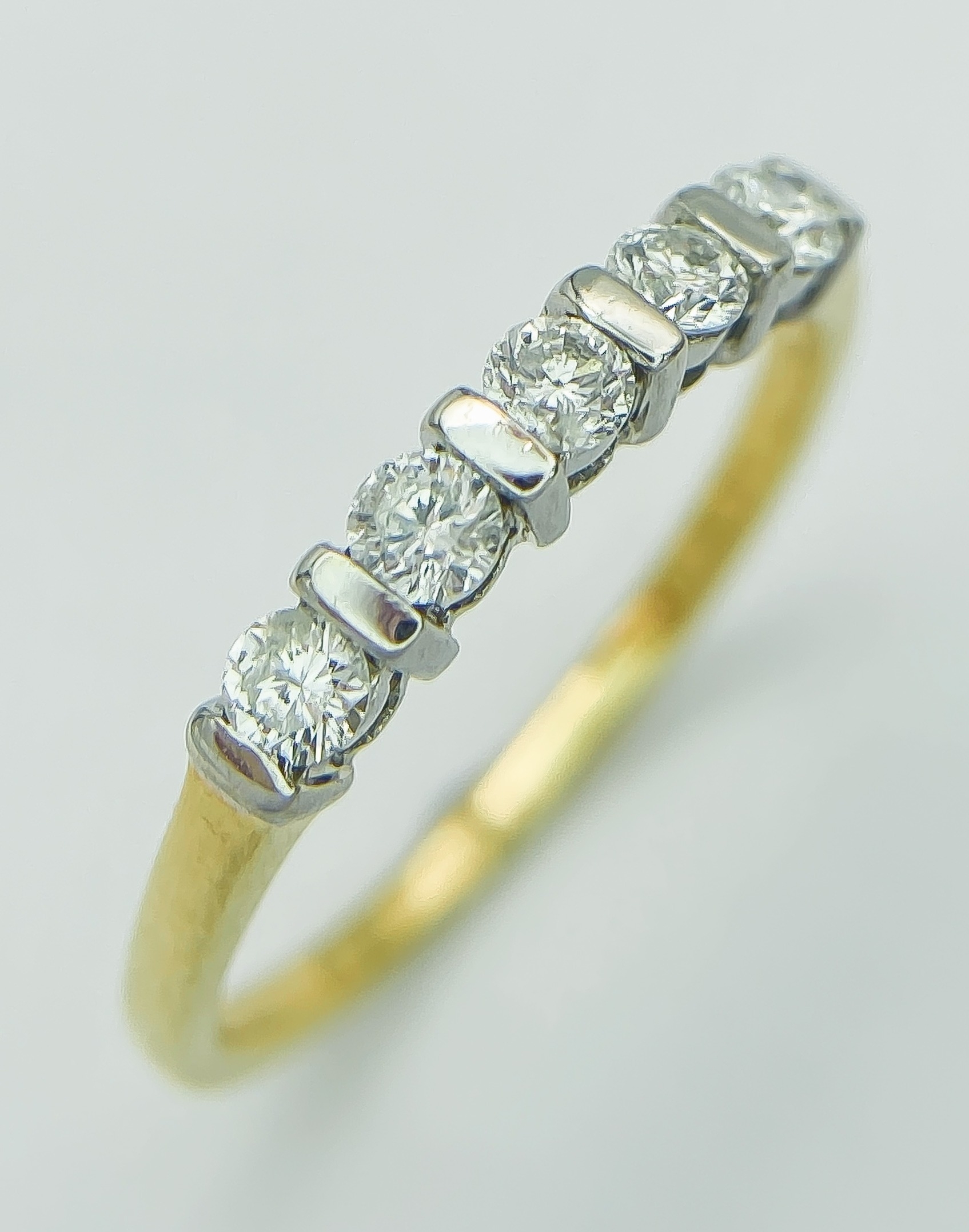 AN 18K YELLOW GOLD AND DIAMOND 5 STONE RING. 0.25CT. 1.8G. SIZE J.