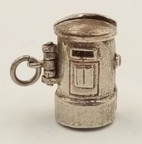 A STERLING SILVER BRITISH POST BOX CHARM, WHICH OPENS TO REVEAL THE POSTMAN INSIDE. 1.6cm x 1.6cm.