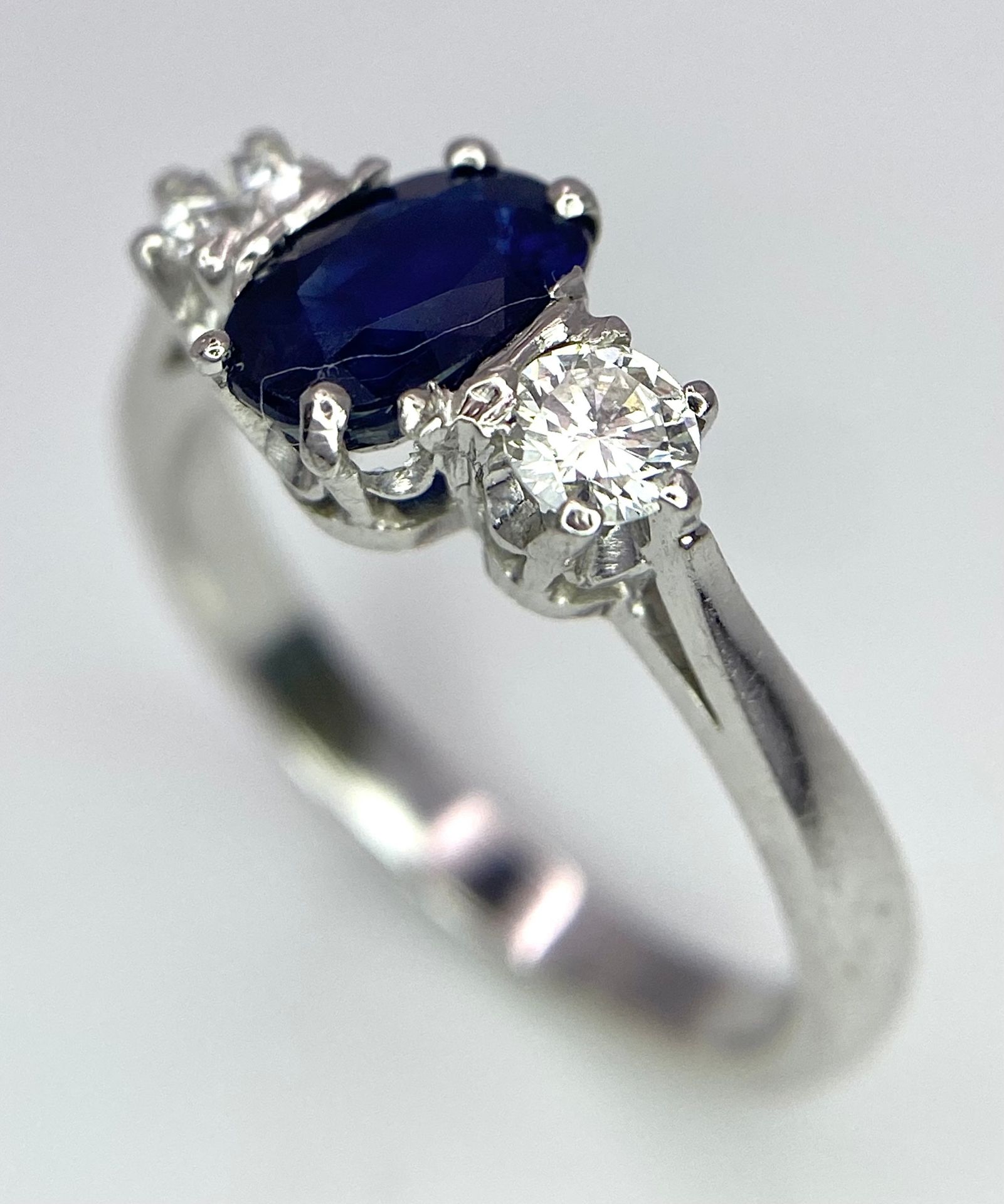 AN 18K WHITE GOLD, DIAMOND AND SAPPHIRE 3 STONE RING. OVAL BLUE SAPPHIRE - 0.75CT AND 0.30CT OF - Image 2 of 6