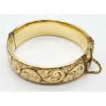 A Gilded Scroll Detail Bracelet. 6.7cm Inner Width. 1.6cm Wide. 30.49 Grams. Slight Dent to