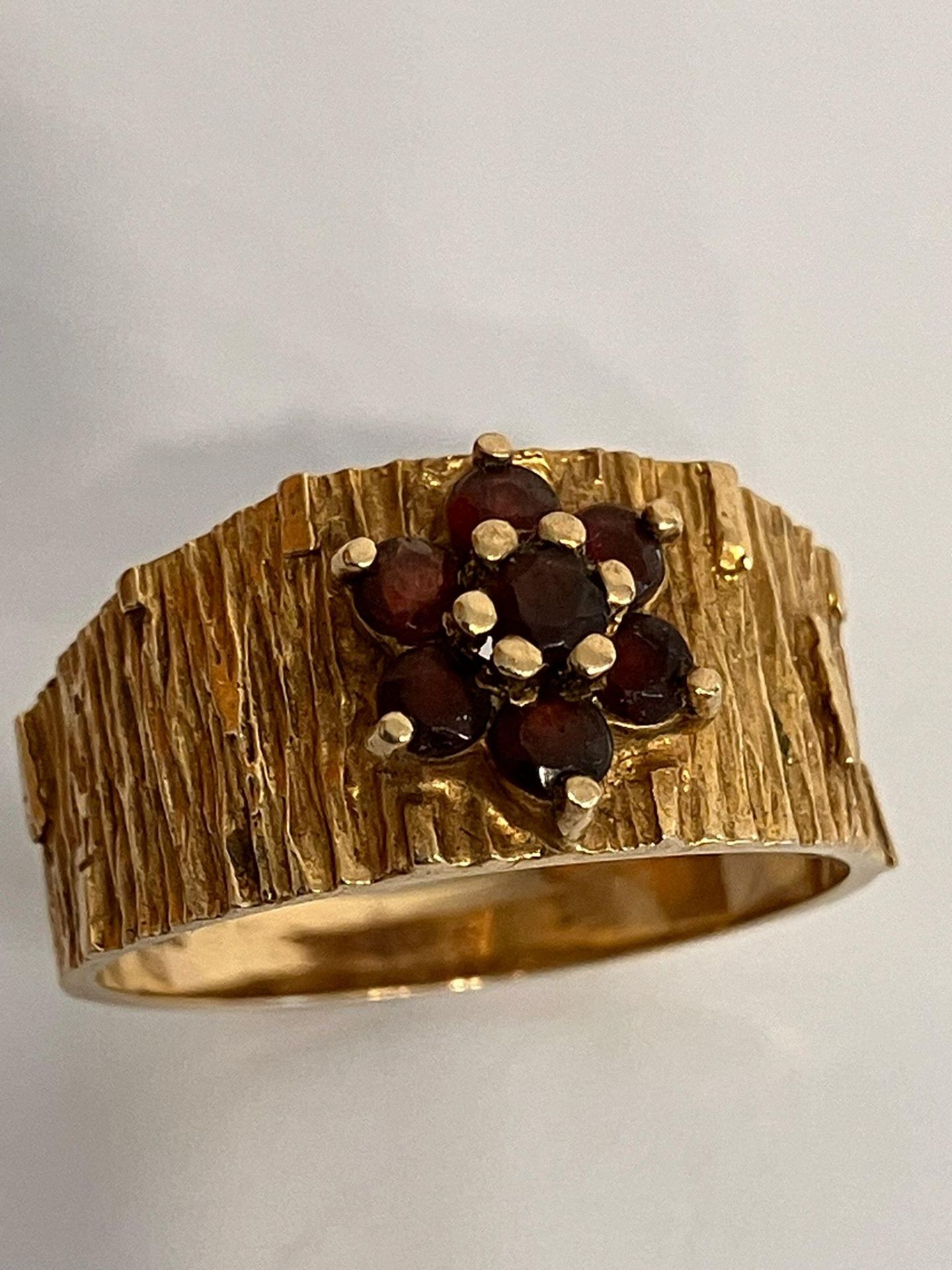 Vintage 9 carat yellow GOLD and GARNET RING, having wide textured band with attractive barked