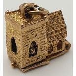 A 9 K yellow gold charm in the shape of a chapel, which opens to reveal a wedding ceremony,