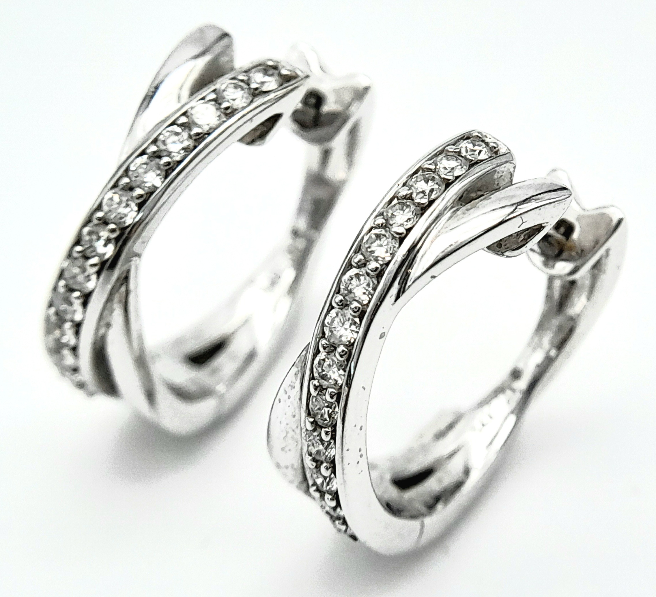 A PAIR OF 14K WHITE GOLD DIAMOND EARRINGS. 0.35ctw, 1.6cm diameter, 4.8g total weight. Ref: SC 8052