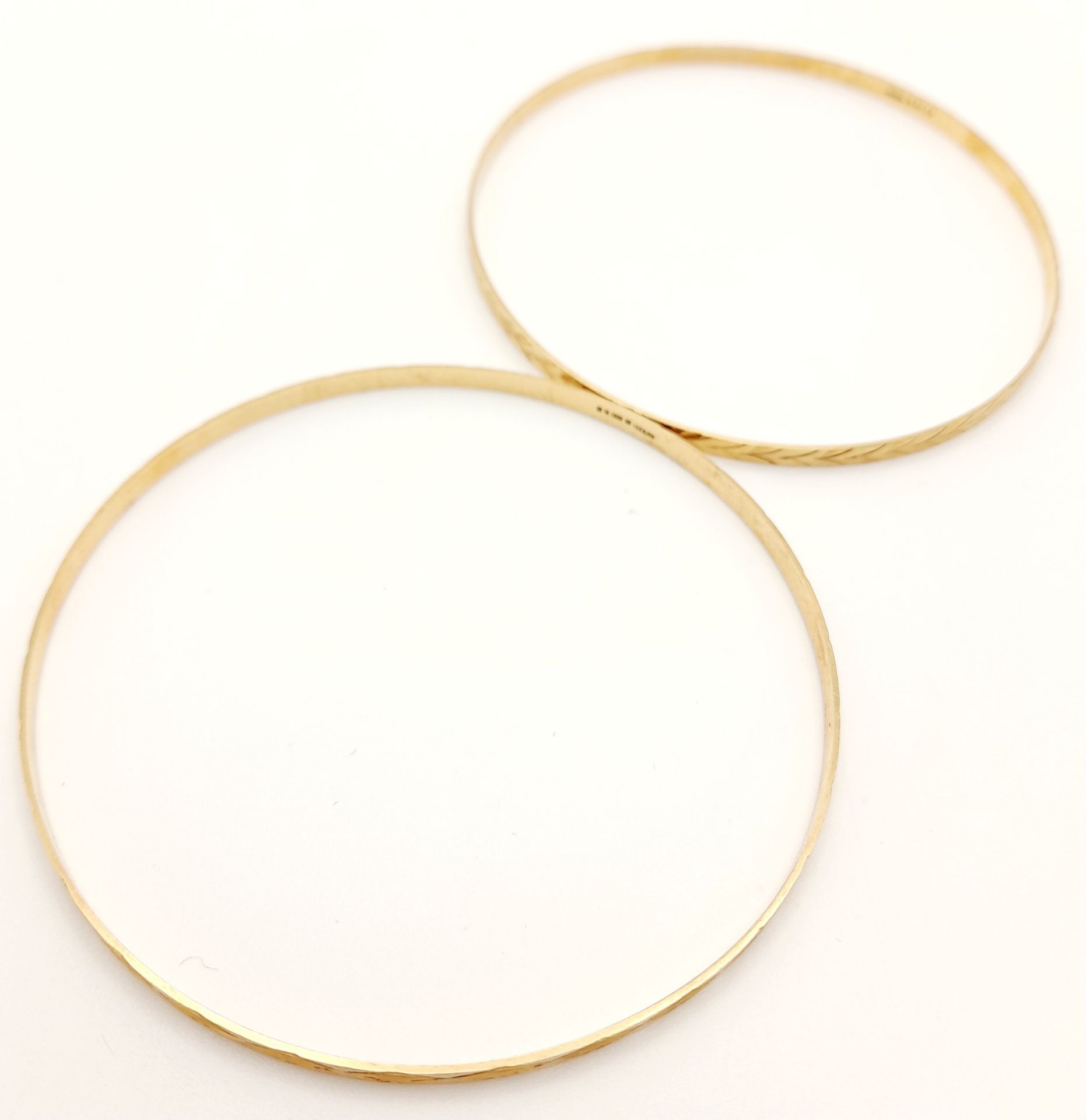 A pair of 9 K yellow gold bangles, each with a different design but perfectly complementing each - Image 2 of 5