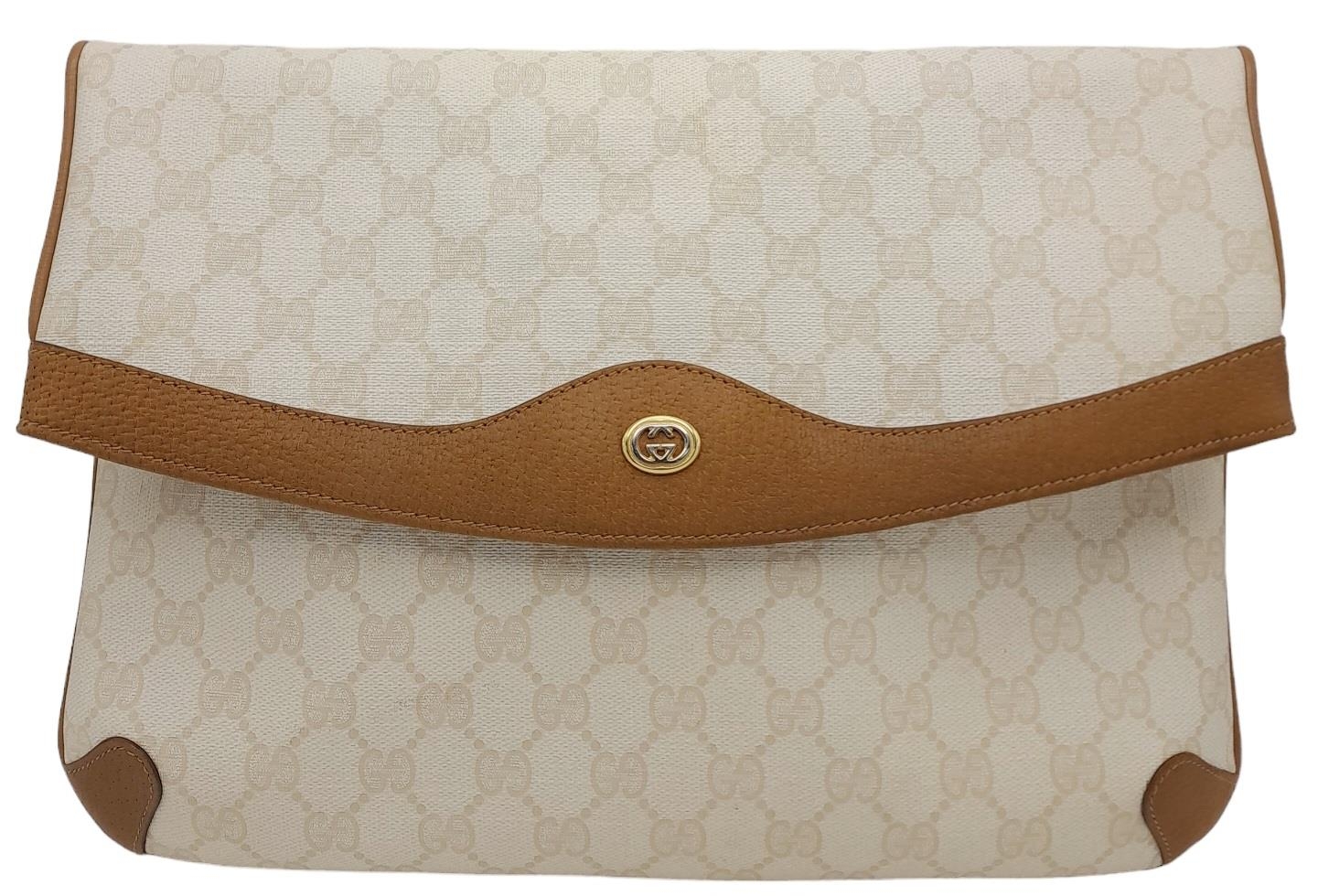 A Gucci Ivory GG Monogram Clutch Bag. Leather exterior with brown trim, gold and silver-toned GG,