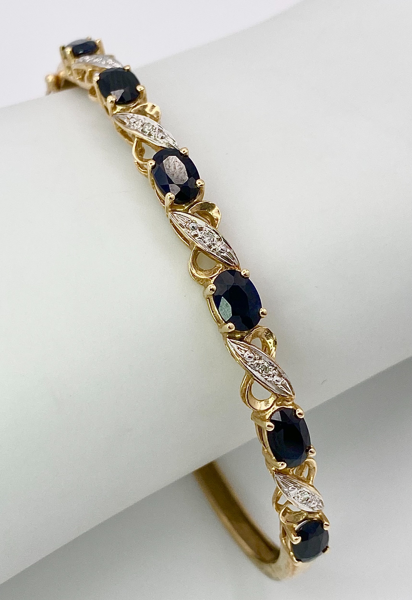 A Vintage 9K Yellow Gold Sapphire and Diamond Bangle. Six oval cut sapphires with diagonal - Image 6 of 6