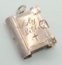 A STERLING SILVER HOLY BIBLE CHARM, WHICH OPENS TO REVEAL THE LORDS PRAYER (loose catch). 2.5cm