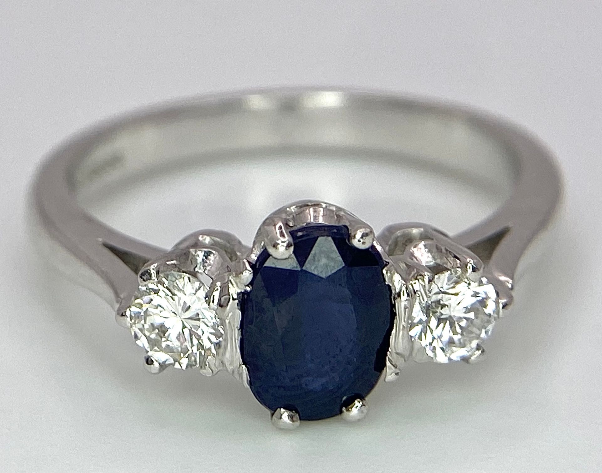 AN 18K WHITE GOLD, DIAMOND AND SAPPHIRE 3 STONE RING. OVAL BLUE SAPPHIRE - 0.75CT AND 0.30CT OF - Image 4 of 6