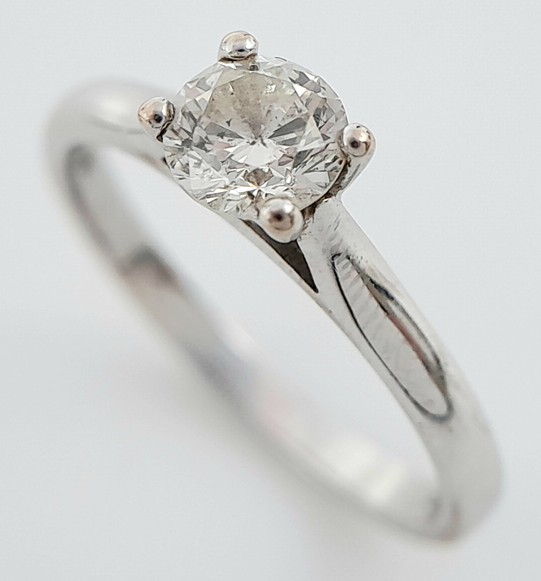 An 18K White Gold Diamond Solitaire Ring. 0.50ct brilliant round cut, slightly tinted. Size N. 2.