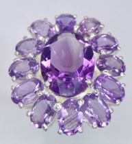 An Amethyst Gemstone Cocktail Ring. Central oval cut large amethyst with an amethyst petal surround.