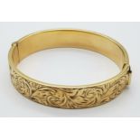 A 9K GOLD VINTAGE HINGED BANGLE WITH A METAL CORE . 23.9gms