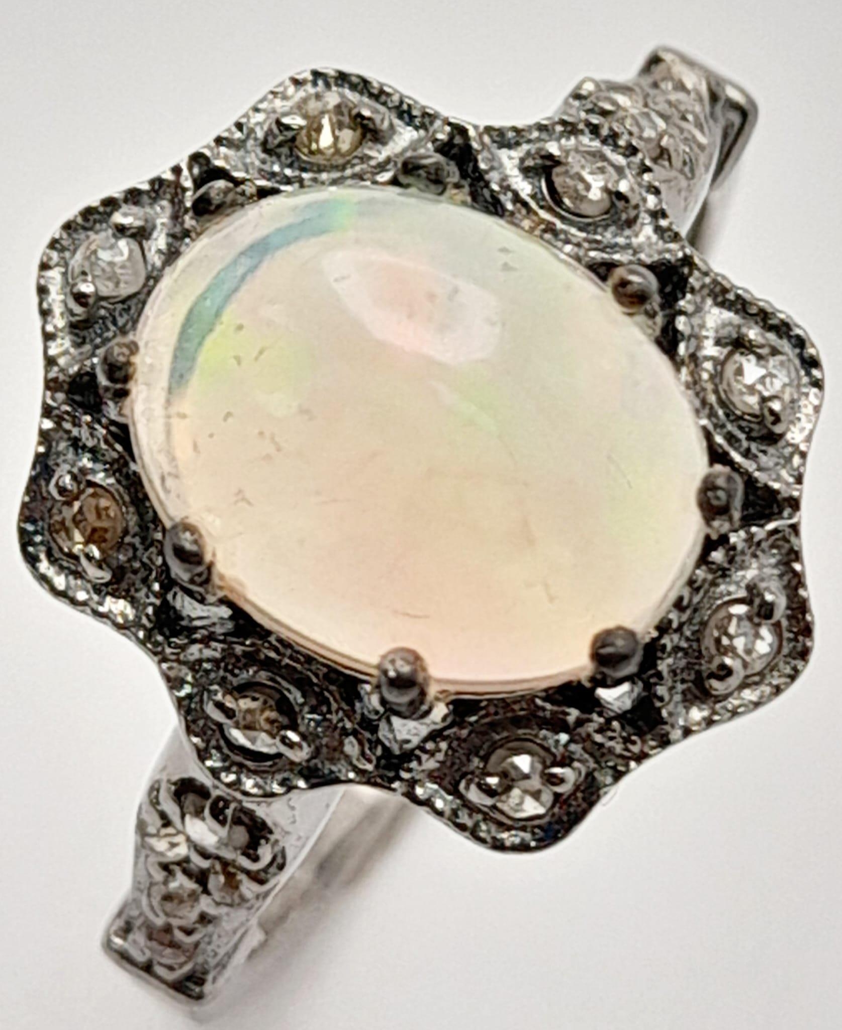 An Ethiopian Opal Ring with Rose Cut diamond Surround and Accents. Set in 925 Sterling silver.
