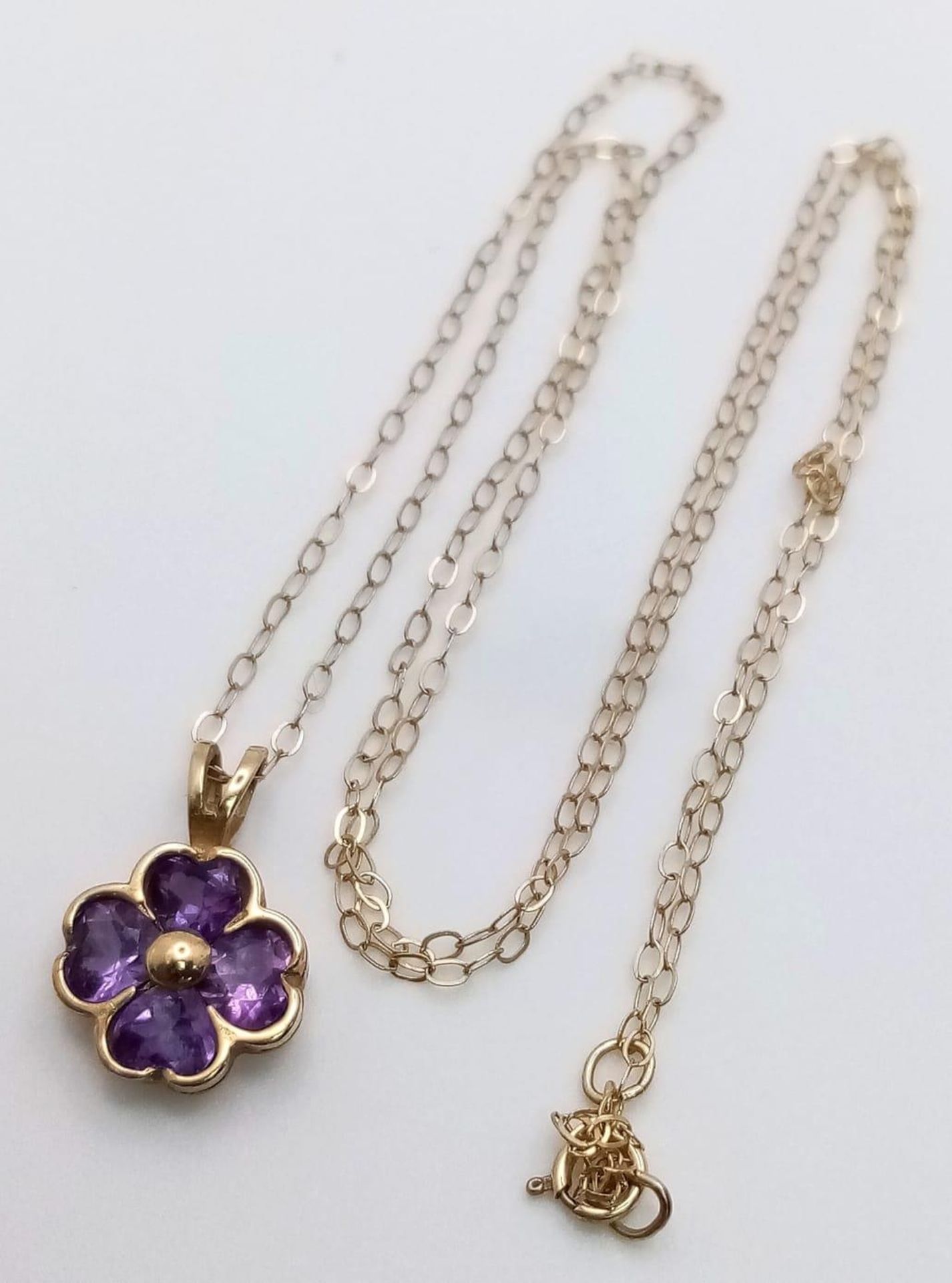 A pretty 9K Yellow Gold (tested as) Amethyst Flower pendant on Necklace, 1.3g total weight, 18”