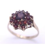 A vintage 9 K yellow gold ring with a cluster of round cut garnets, size: Q, weight: 2.5 g.