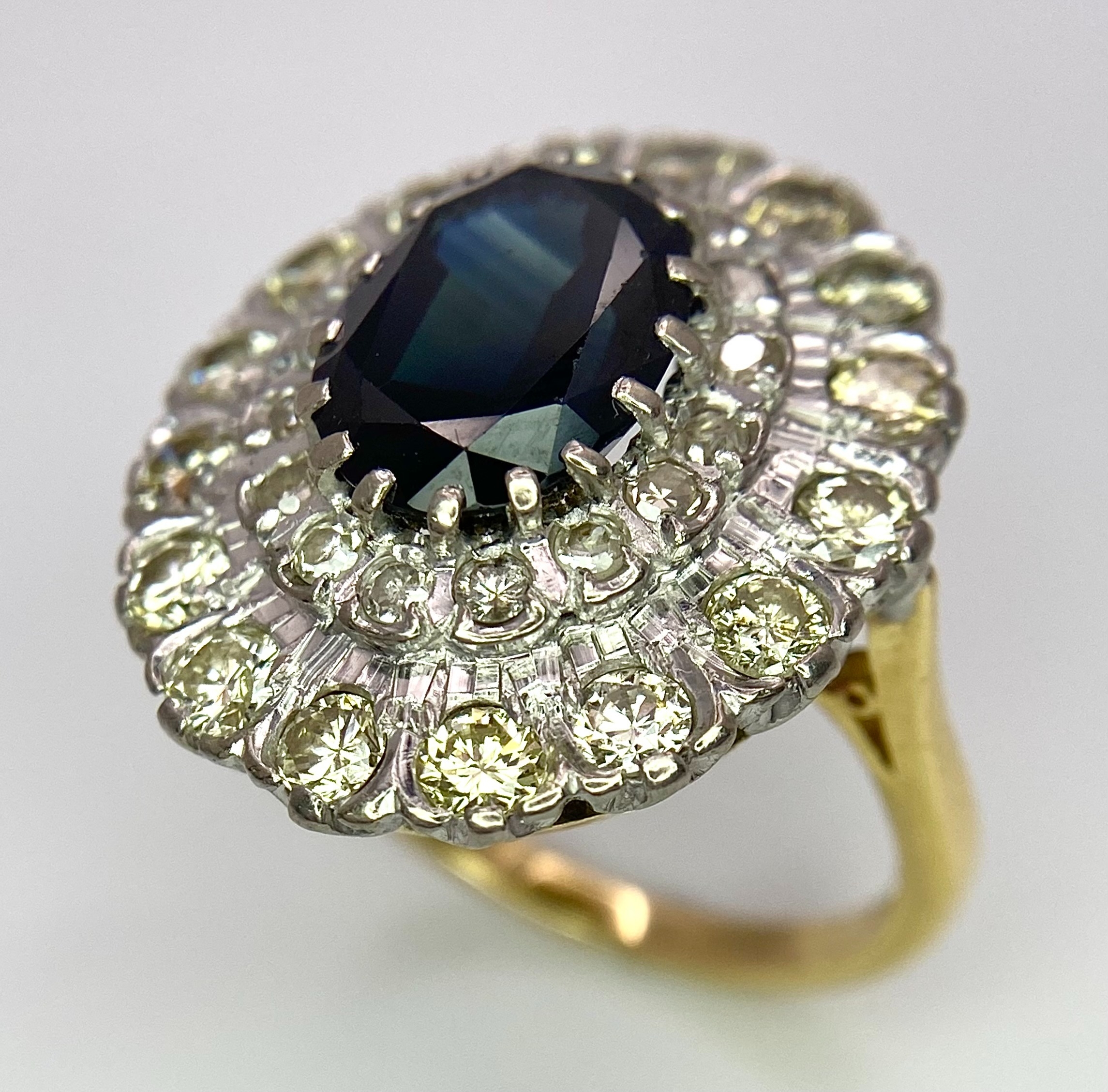 A Breath-Taking 18K Yellow Gold, Sapphire and Diamond Dress Ring. Central oval cut 3ct sapphire with