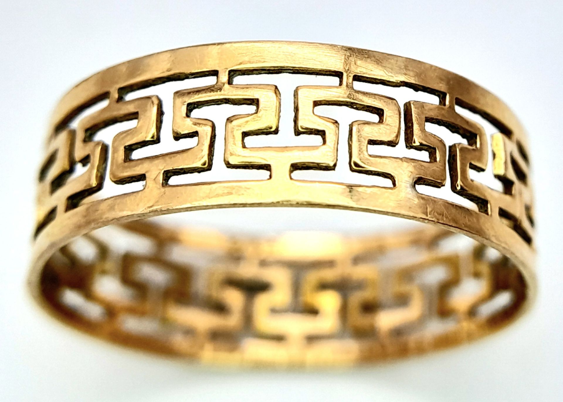 A 9 K yellow gold ring with a pierced Greek key design, size: N, weight: 1.4 g.