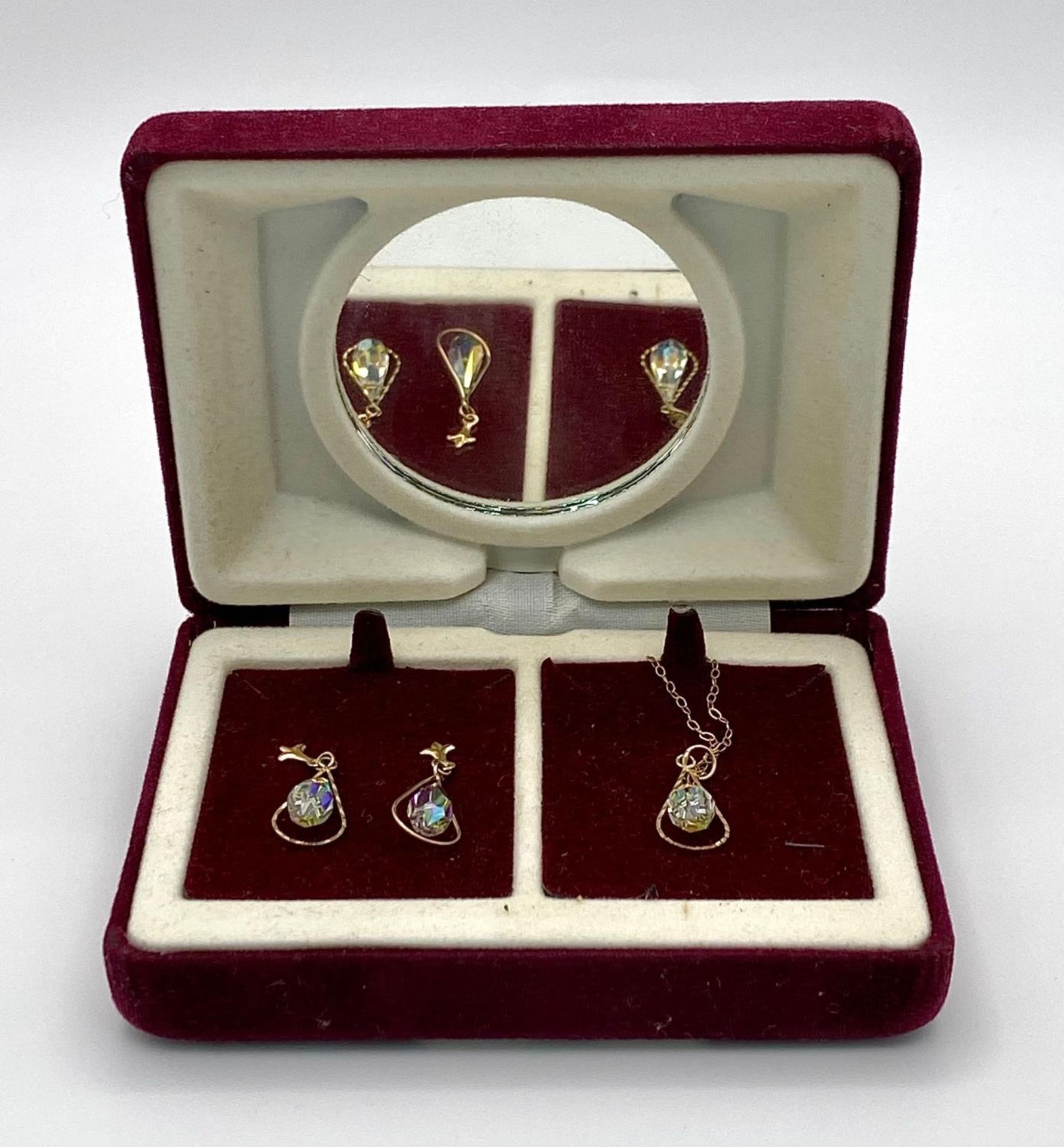 A vintage 9 K yellow gold earrings and pendant set with chain. Adorned with mystic crystals. In