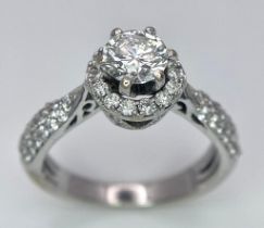 An 18K White Gold Diamond Ring. Central 0.75ct brilliant round cut diamond with a diamond halo and