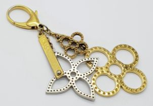 A Louis Vuitton Bijoux Sac Tapage Charm/Key Ring. Gold and silver-toned hardware with iconic LV