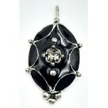 An Antique Black Enamel and Silver Pendant. 3cm