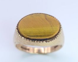 A 9 K yellow gold cygnet ring with a quality tiger's eye oval flat cabochon, size: Q, weight: 4.3 g