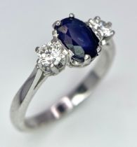 AN 18K WHITE GOLD, DIAMOND AND SAPPHIRE 3 STONE RING. OVAL BLUE SAPPHIRE - 0.75CT AND 0.30CT OF