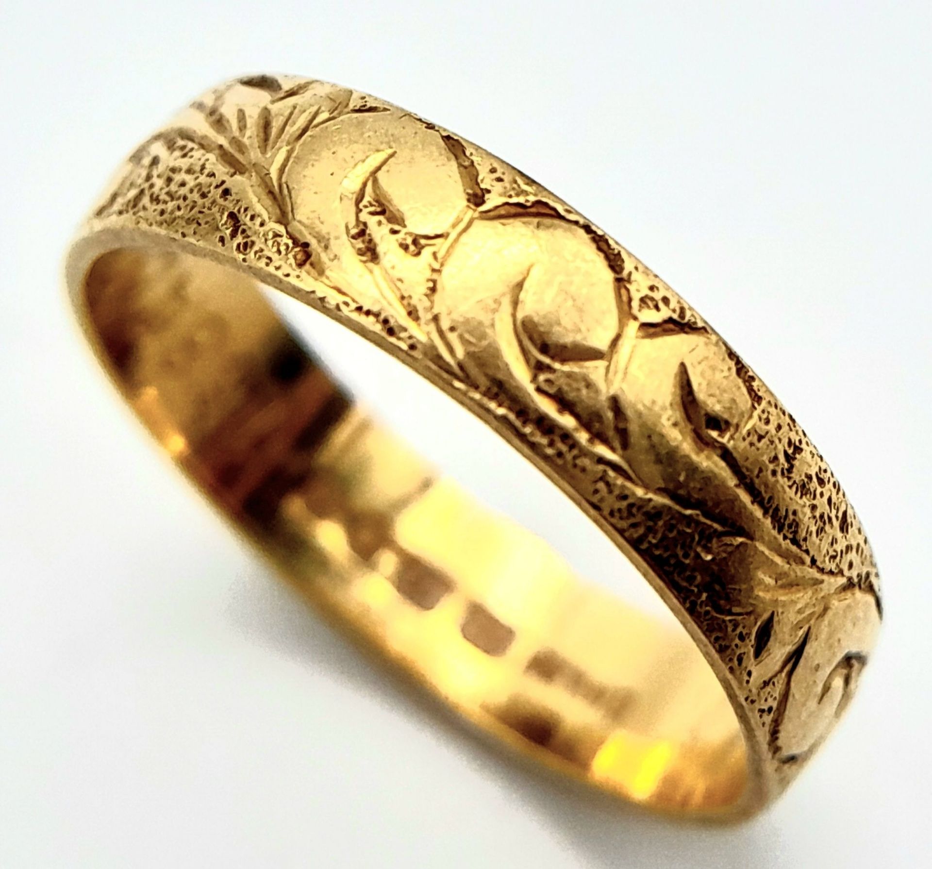 An 18 K yellow gold band ring with an engraved surface. Size: L, weight: 2.5 g.