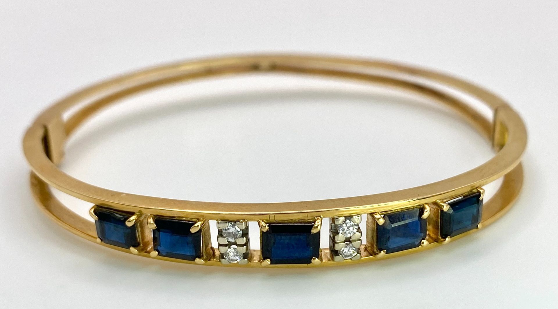 A 14K (TESTED AS) YELLOW GOLD BANGLE SET WITH 5 SAPPHIRES AND 4 DIAMONDS, 6CM DIAMETER, 15.9G (DIA: