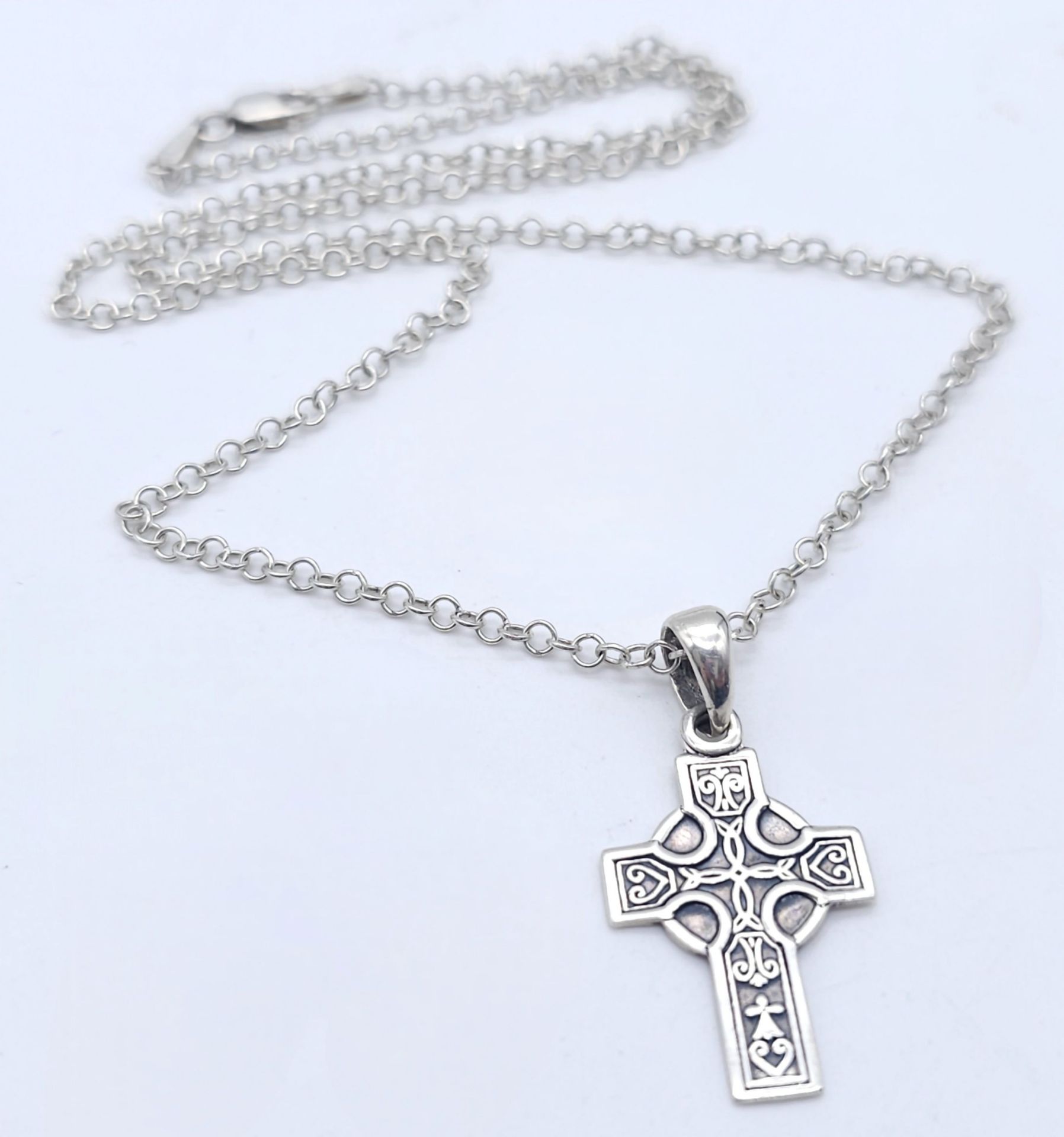 A SILVER CELTIC DESIGN CROSS PENDANT ON A 42cms SILVER CHAIN. 5.5gms