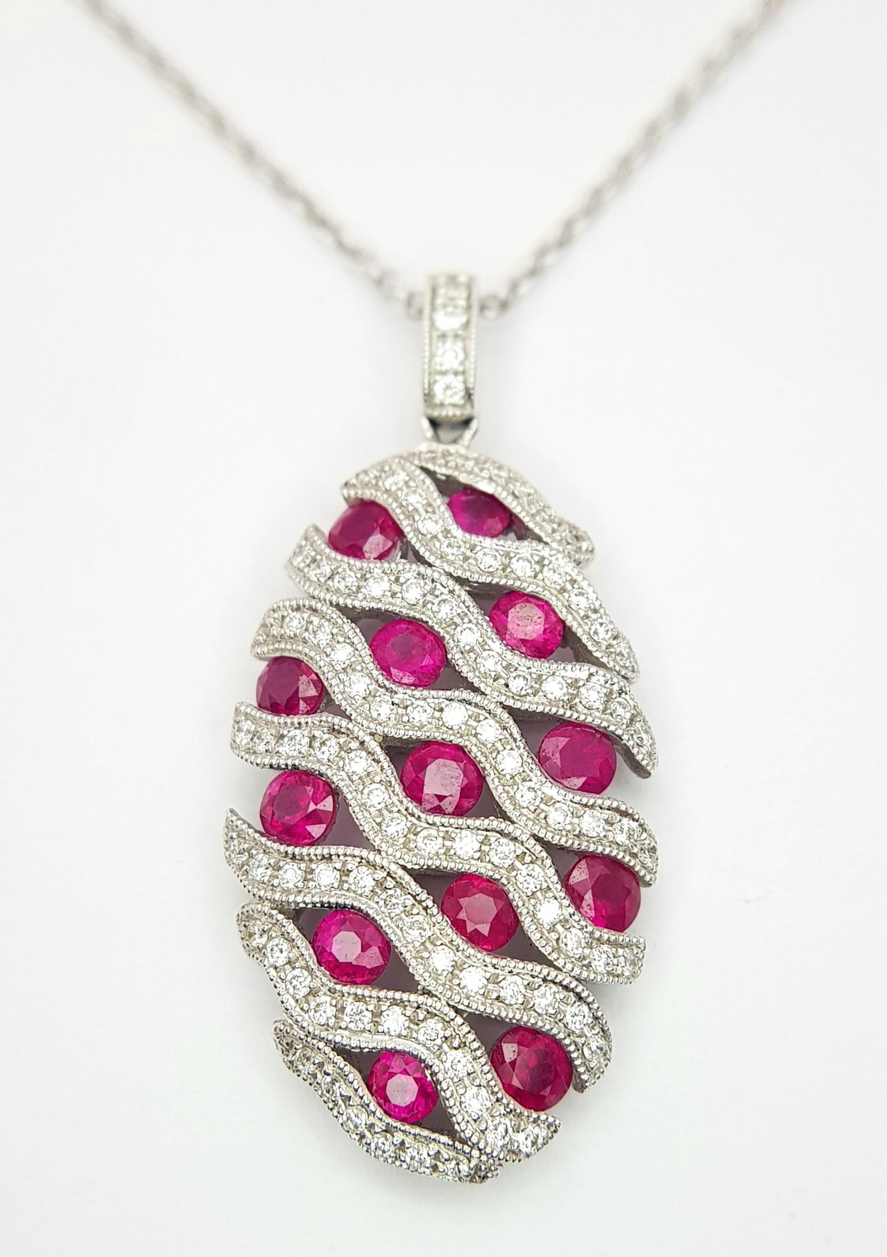 AN 18K WHITE GOLD DIAMOND AND RUBY PENDANT - 0.49CT OF DIAMONDS AND 2.29CT OF RUBIES. 6.2G WEIGHT.