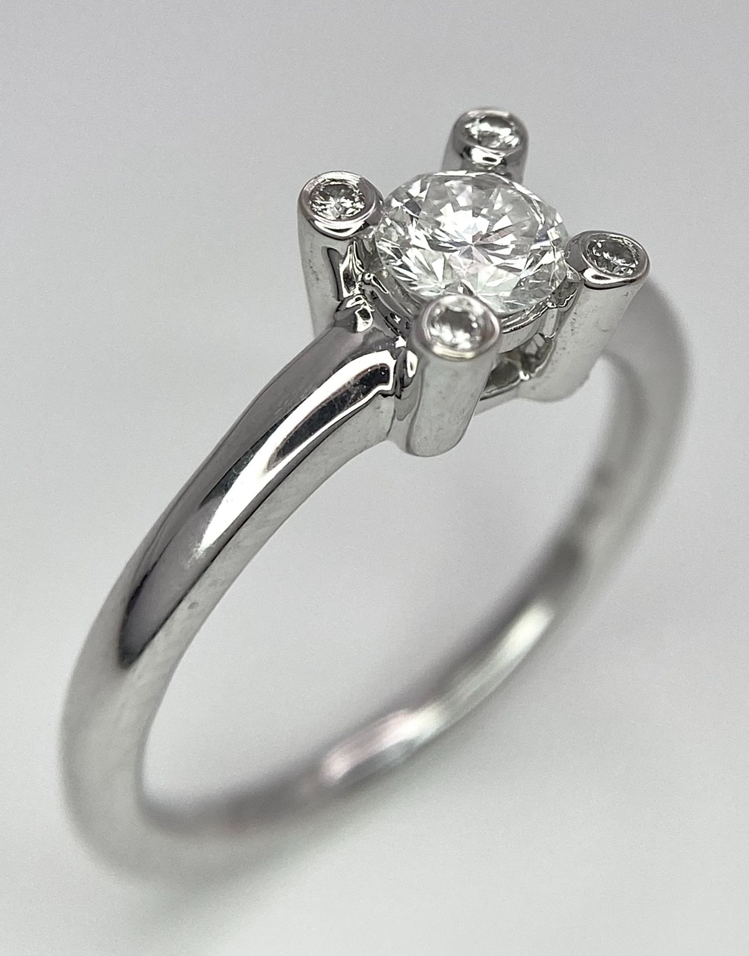 AN 18K WHITE GOLD DIAMOND SOLITAIRE RING WITH FOUR DIAMOND TURRETS - 0.50CT 4.6G. SIZE M 1/2. - Image 2 of 10